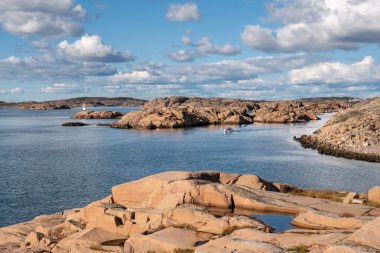 Skagerrak Denizi kıyısındaki Hamburgo, Bohuslan 'da Sandviksholmen' de seyir feneriyle granit kovanlardan geçen motorlu tekneler.