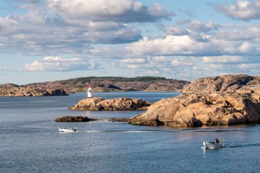 Hamburgsund Archipelago, İsveç - 21 Ağustos 2025: İsveç 'in Skagerrak Denizi kıyısındaki Bohuslan' da Sandviksholmen 'de deniz feneriyle Granit skerries arasında yol alan iki sürat teknesi