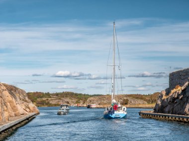 Sotekanalen, İsveç - 24 Ağustos 2025: Sotekanalen, Sote Canal, Bohuslan, batı kıyısı İsveç 'te dar kanal boyunca granit kayalar bulunan tekneler