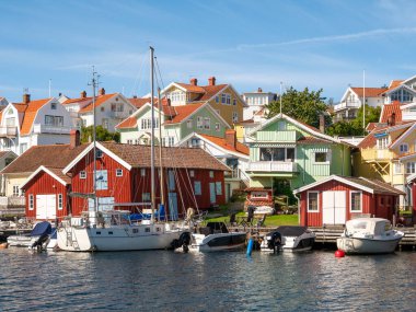 Fiskeback skil, İsveç - 25 Ağustos 2025: Tekneli liman ve Skafto Adası, Bohuslan, batı kıyısı İsveç 'teki Fiskeback skil' de renkli rıhtım evleri