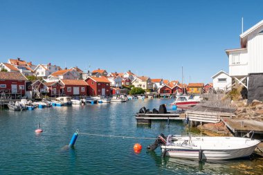 Grundsund, İsveç - 25 Ağustos 2025: Grundsund, Skafto Adası, Bohuslan Takımadası, İsveç 'in batı kıyısındaki liman kanalı boyunca tekne ve rıhtım evleri