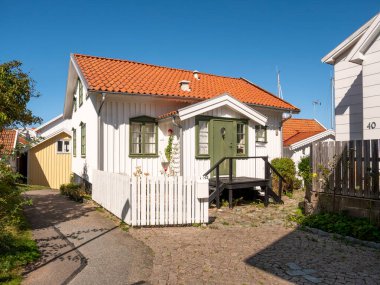 Grundsund, İsveç - 25 Ağustos 2025: İsveç 'in batı kıyısındaki Bohuslan takımadası, Skafto adasındaki Grundsund köyünde küçük bir sokak boyunca geleneksel ahşap ev