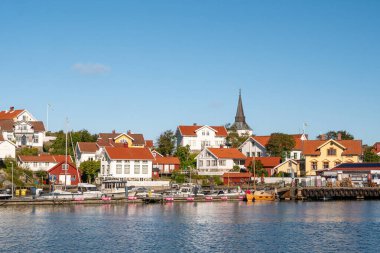 Gullholmen, İsveç - 26 Ağustos 2025: Harmano adasındaki Gullholmen köyünün limanı ve kilisesi, Bohuslan takımadası, batı kıyısı İsveç