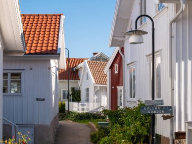 Gullholmen, İsveç - 26 Ağustos 2025: Gullholmen, Bohuslan, batı kıyısındaki Gatan 'daki ahşap evler arasında dar sokak sahnesi