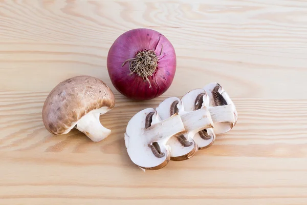 Setas castañas y cebolla roja sobre madera — Foto de Stock