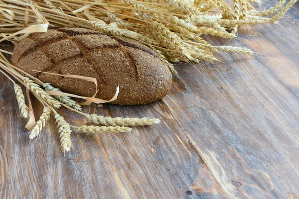 Una barra de pan y espigas de trigo —  Fotos de Stock