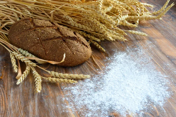 Una barra de pan y espigas de trigo —  Fotos de Stock
