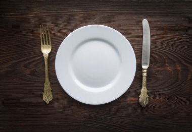 Boş levha ve ahşap masa üzerinde Gümüş eşyalar