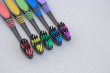 Gri arkaplanda çok renkli diş fırçaları seti