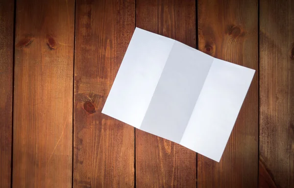 Folleto en blanco de papel triple maqueta sobre mesa de madera —  Fotos de Stock