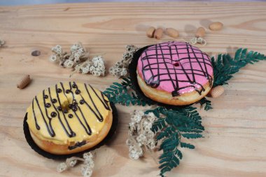 Ahşap arka planda izole edilmiş renkli serpiştirilmiş donut..