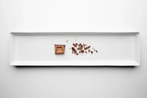 Pieza de chocolate se desmorona aislado en el centro blanco —  Fotos de Stock
