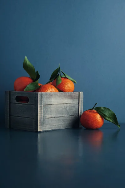 Tuoreet mandariinit laatikossa, jossa lehdet eristetty — kuvapankkivalokuva