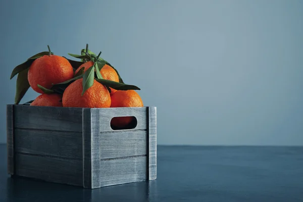 Tangerinas frescas em caixa com folhas isoladas perto — Fotografia de Stock