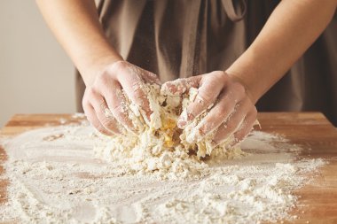 Woman hands knead dough for pasta clipart