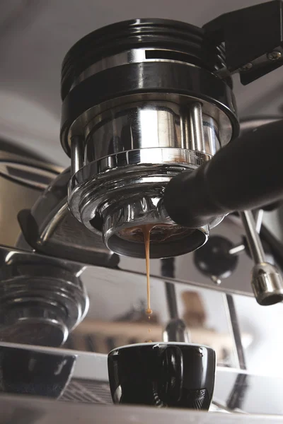 Closeup café expresso derramando da máquina de café xícara preta — Fotografia de Stock