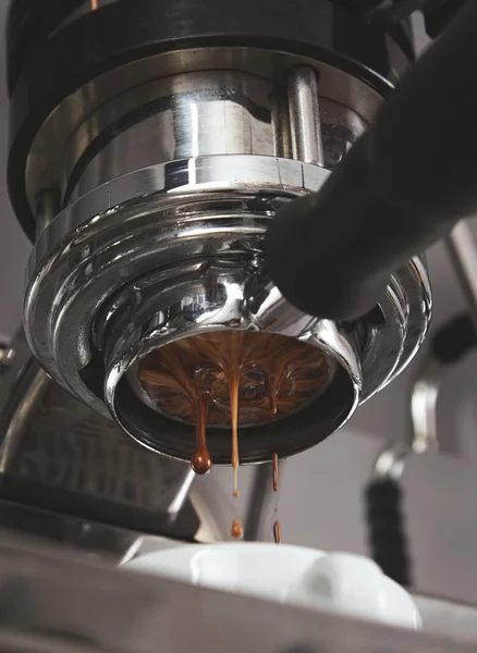 Las gotas de café de primer plano caen de la máquina de café expreso —  Fotos de Stock