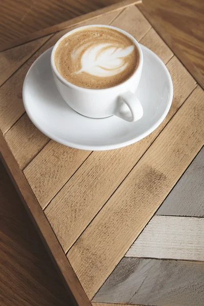 Cappuccino fincan desenli ahşap plaka üzerinde izole — Stok fotoğraf