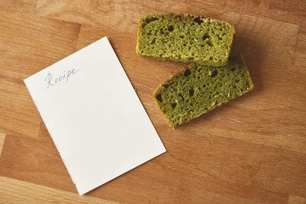 Pane di spinaci a due fette isolato con ricetta su tavola di legno — Foto Stock