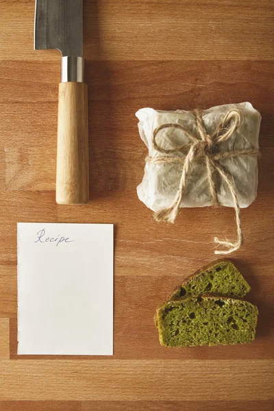 Knife, spinach bread, recipe and two slices isolated top view — Stock Photo, Image