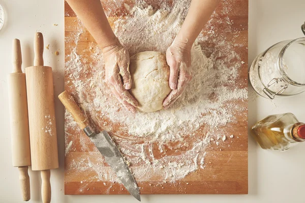 Woman hands hold prepared dough top view — Stock Photo, Image