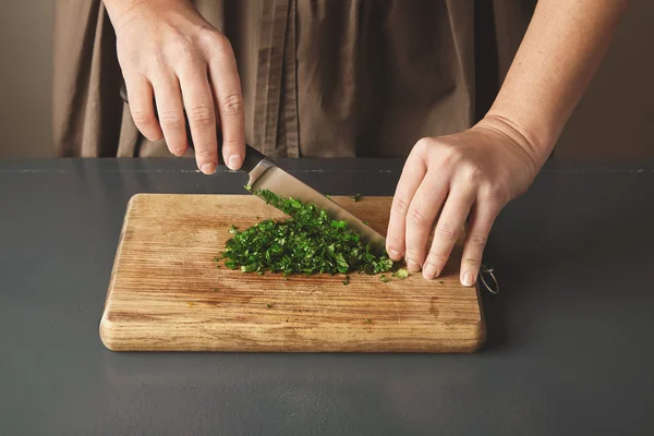 Women hand chop parsley on wooden board — Stock Photo, Image