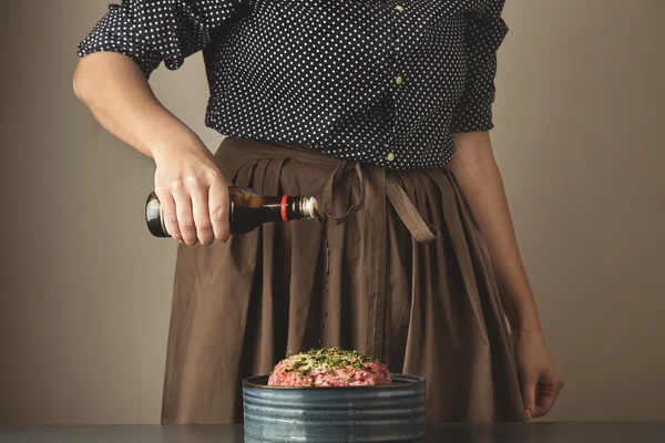 女性はミンチ肉に醤油を注ぐ — ストック写真