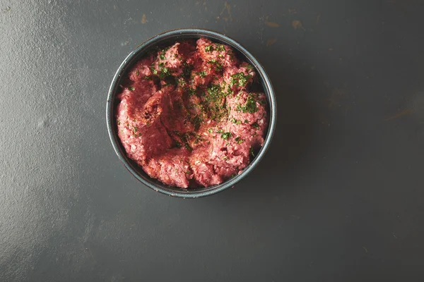 Ovanifrån på malet kött med kryddor i blå keramik — Stockfoto