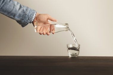 El şişeden bardağa temiz su döker