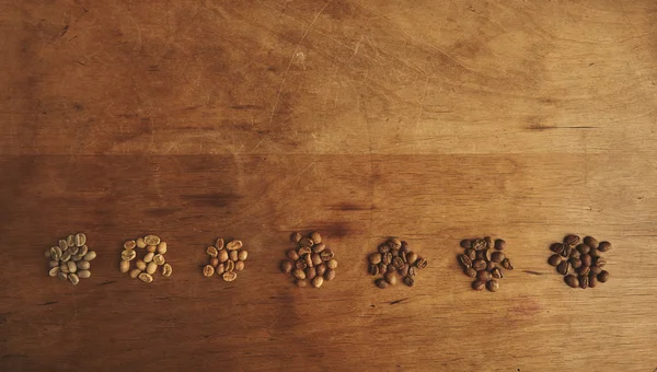 Färska olika kaffebönor sju sorter rostning uppifrån Visa rad — Stockfoto