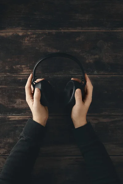 Zwei Hände halten drahtlose Kopfhörer mit Lederohrpolstern — Stockfoto