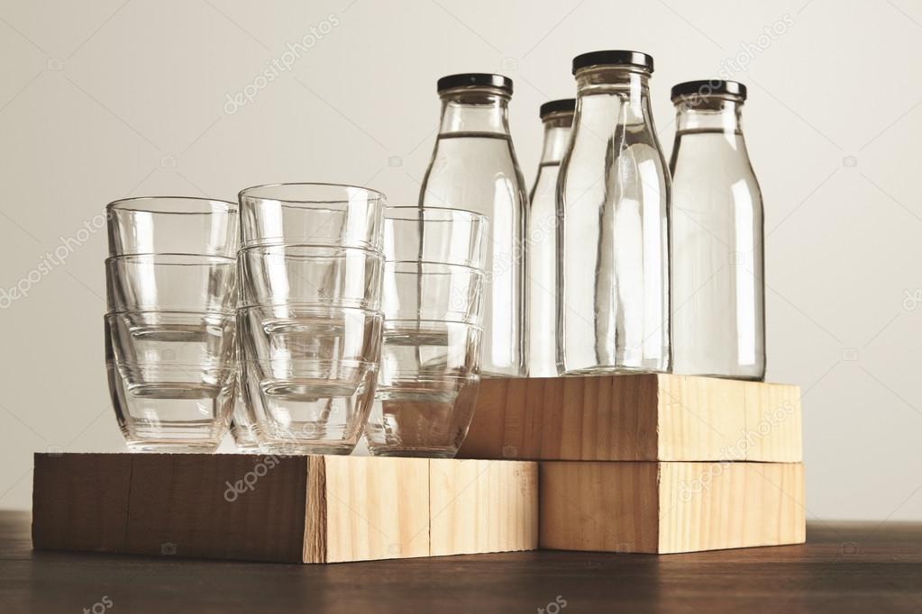 Set glasses and bottles with water on wooden table