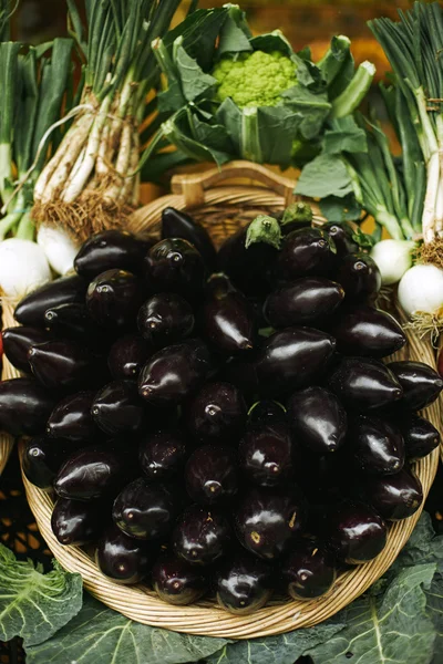 Färska äggplantor i korg presenteras utanför i marknaden till salu — Stockfoto