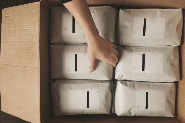 Tangan menempatkan paket kosong dalam kotak karton kerajinan besar — Stok Foto