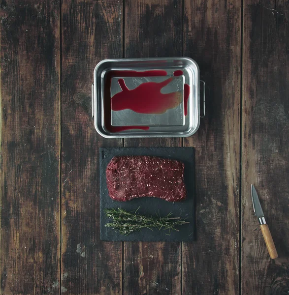 Top vista carne corante faca de sangue mesa de madeira pedra de erva — Fotografia de Stock