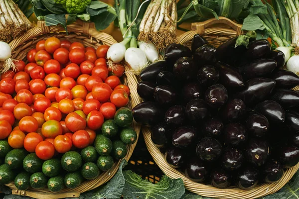 Pomodori rossi freschi, melanzane zuccherine in cestini fuori mercato — Foto Stock