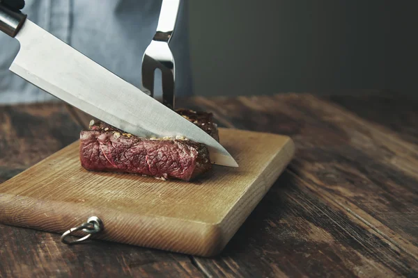 Couteau tranche coupée de viande grillée sur planche de bois — Photo