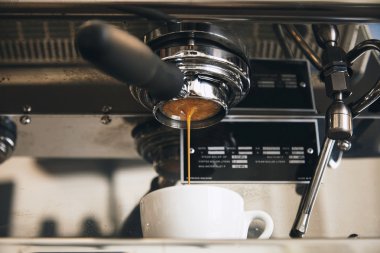 Fresh espresso coffee brewing through the bottomless portafilter