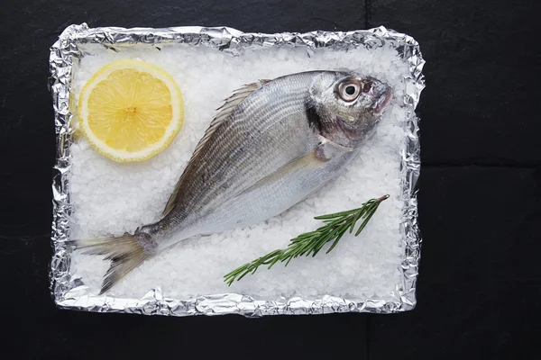 PRÉSENTATION DE Dorade de mer sauvage fraîche en papier aluminium métallisé — Photo