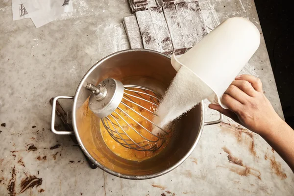 Messbecher Zucker in großem Stahleimer voller Eier — Stockfoto