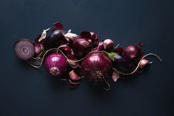 Red onions and cut halves, peeled and not, with small baby eggplants