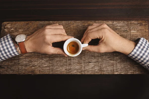 Buchhalter Hand in kariertem Hemd hält kleine Tasse mit Espresso — Stockfoto