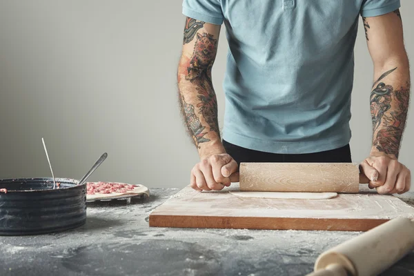 Tetovaný hlavní muž vaří pelmeni — Stock fotografie