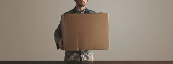 Bearded man holds big carton paper box with goods — Stock Photo, Image