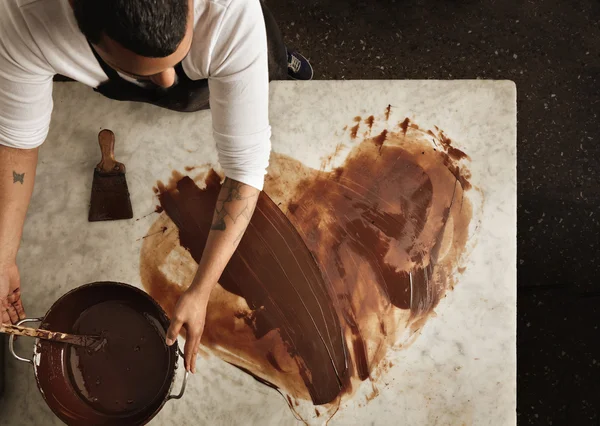 Bäcker zeichnet mit heißer Schokolade ein schönes Herz — Stockfoto