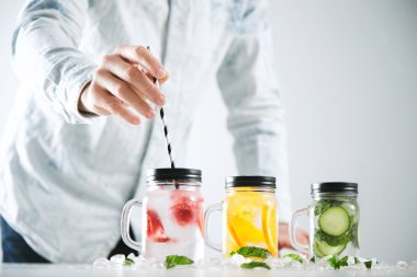 Bartender puts striped drinking straw  