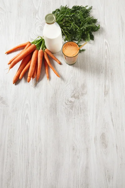 Урожай моркви лежить біля пляшки — стокове фото