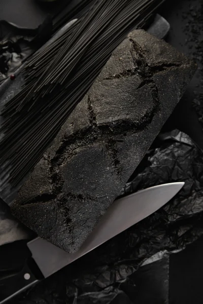 Fekete spagetti a pultnál fekete kenyérrel — Stock Fotó