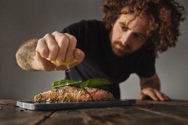 Adam çiğ somon limon sıkıyor 