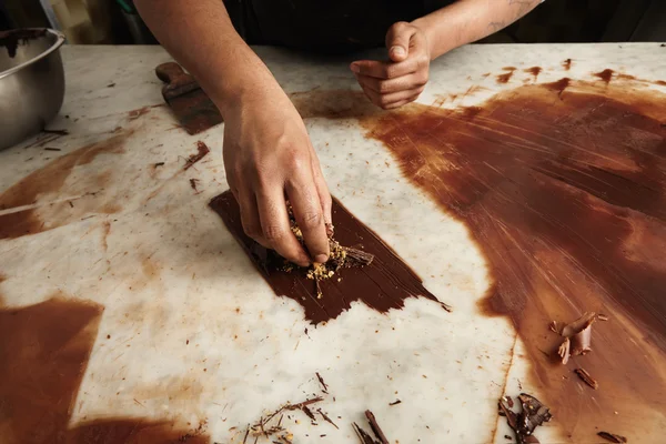 Chief cook circles from melted homemade chocolate with nuts — Stock Photo, Image